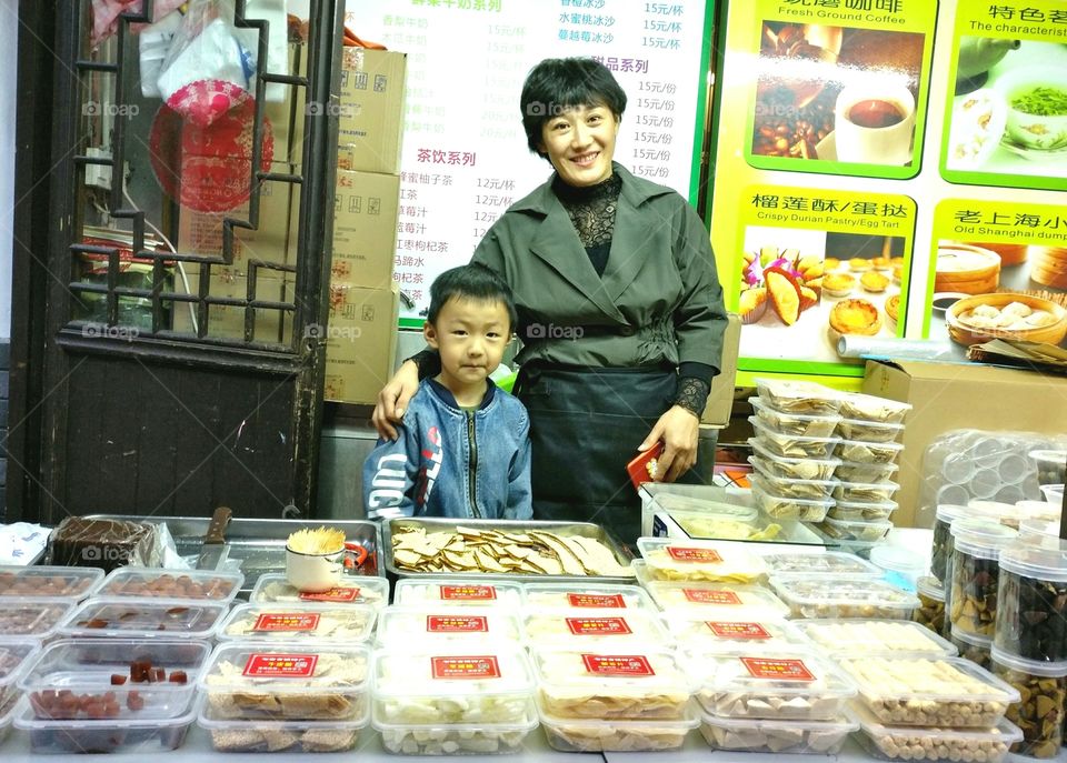 Cute Chinese mother and son at their shop in Qibao, ancient watertown district of Shanghai, China