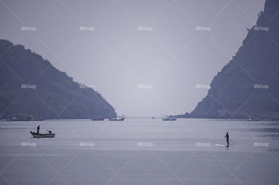 Tourists on surf boards in the sea at Prachuap Bay in Thailand.