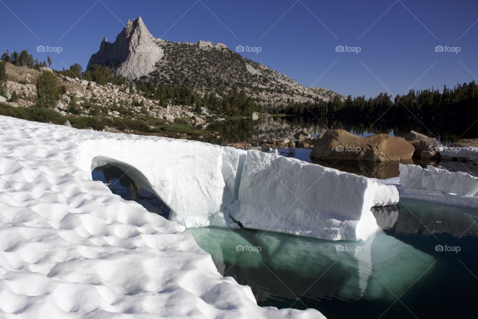 Cathedral Peak towers over a melting glacial bridge in Yosemite National Park, California