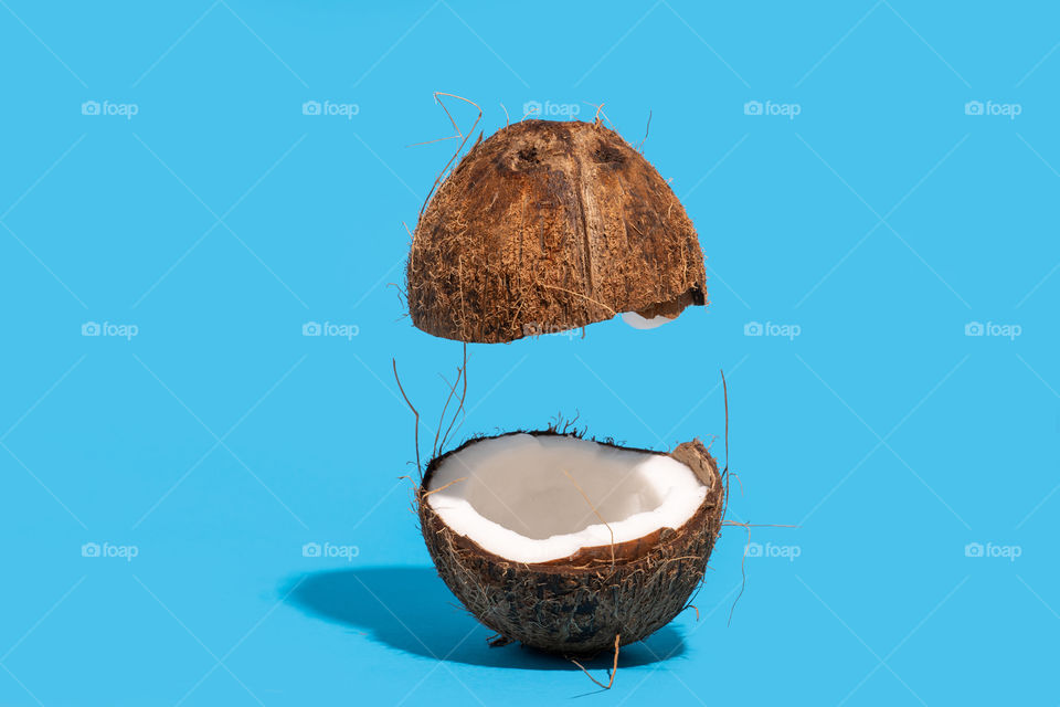 Coconut split on half with one half floating on air