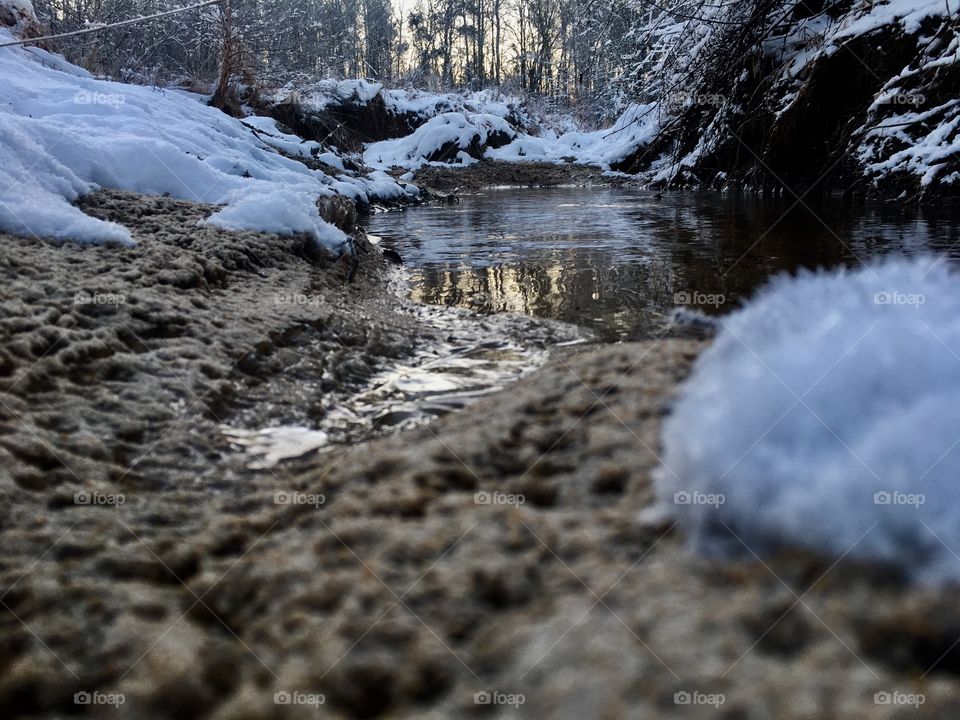 Shore of creek winding through a winter wonderland 
