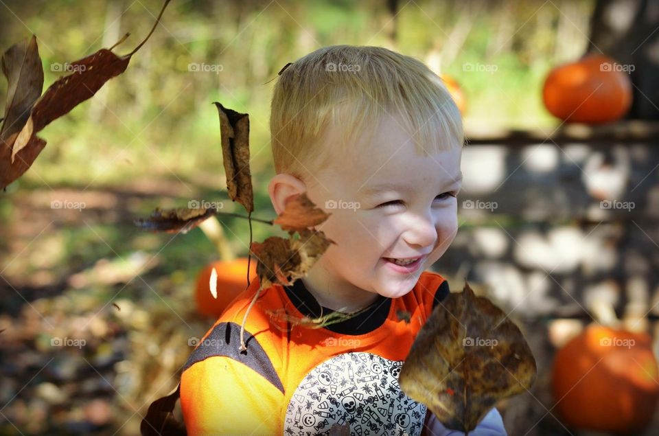 Sweet baby boy playing in the leaves 