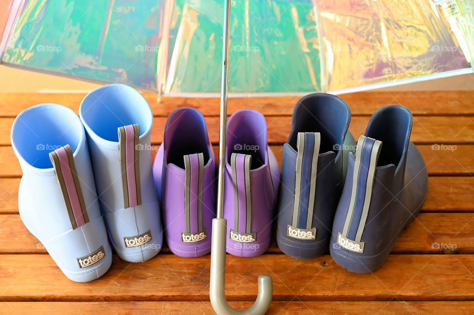 Colorful rain boots under the umbrella 