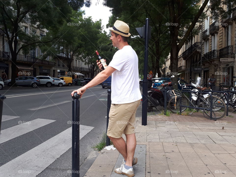 Man with bottle of wine at the street of Bordeaux