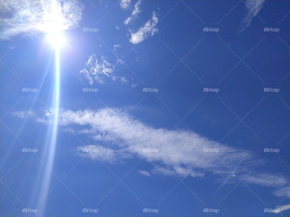 Rays of the mid June afternoon sun coming down through the clouds