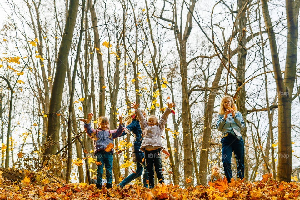 Kids playing with fall foliage