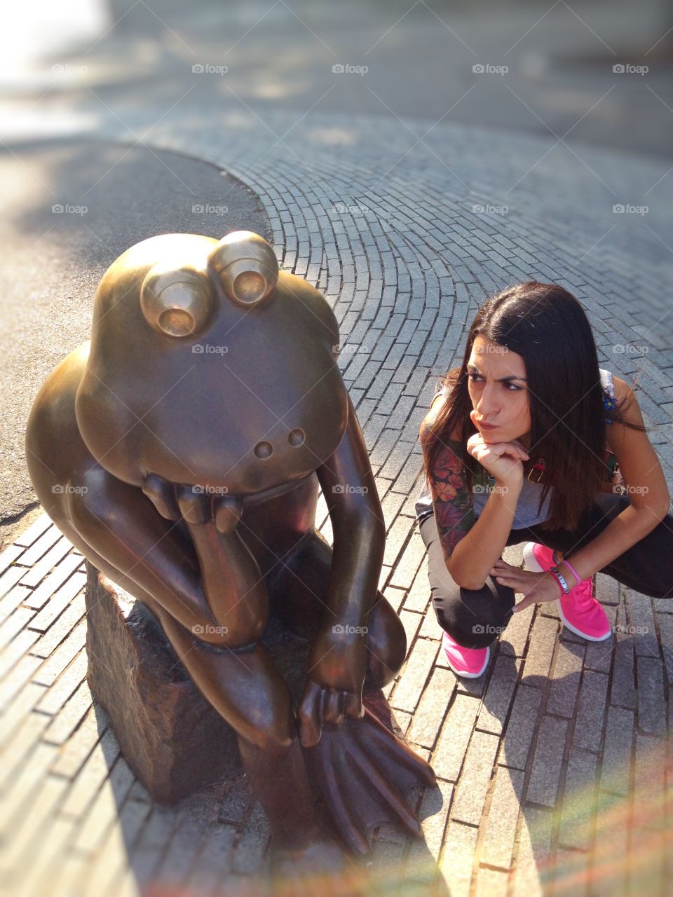  Two frogs. A Woman look like a frog statue