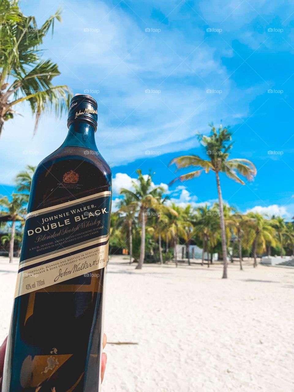 One of the best-selling alcoholic drink in Indonesia is Jonny Walker Blue Label. This photo further emphasizes not only the drink, but also the nice weather and beautiful beach in Indonesia, especially in Bali Island.