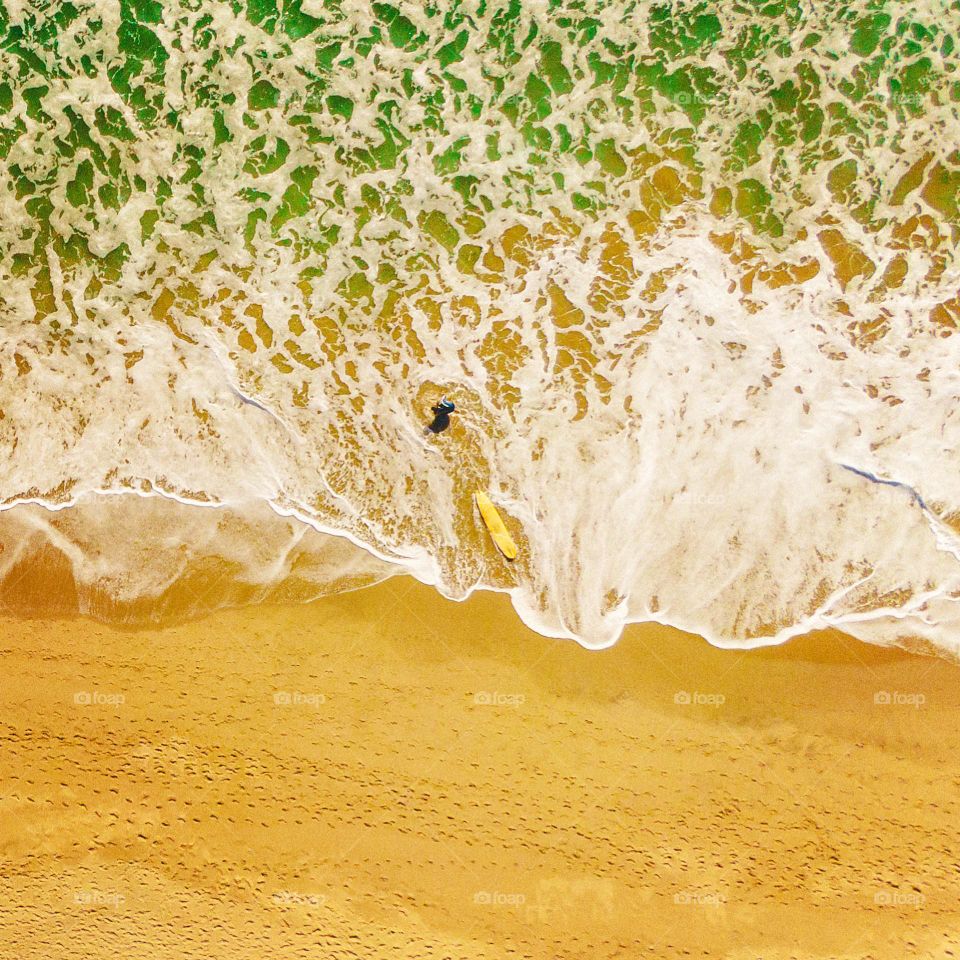 A surfer ventures out into the ocean at Silver Strand Beach in Oxnard, CA.