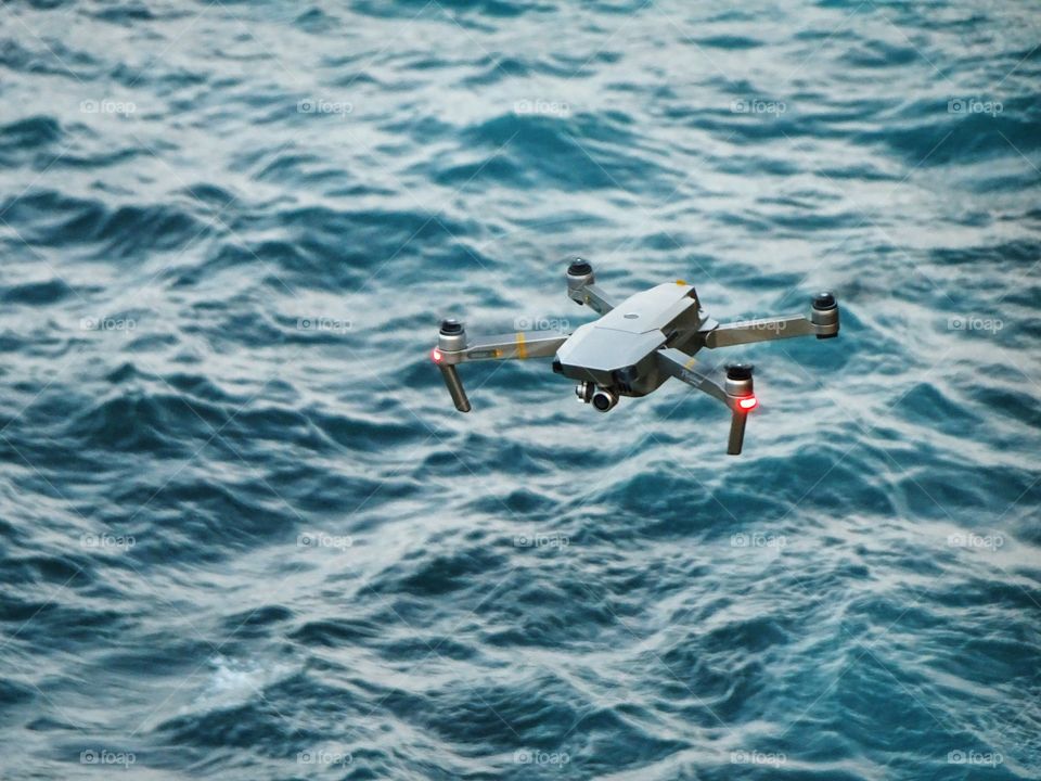 You never know who's watching you!  Drone technology. A drone flying high above the stormy raging ocean. 