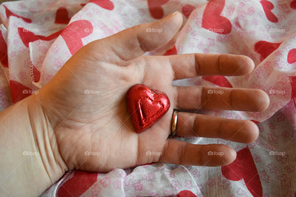 Hand holding heart shaped candy