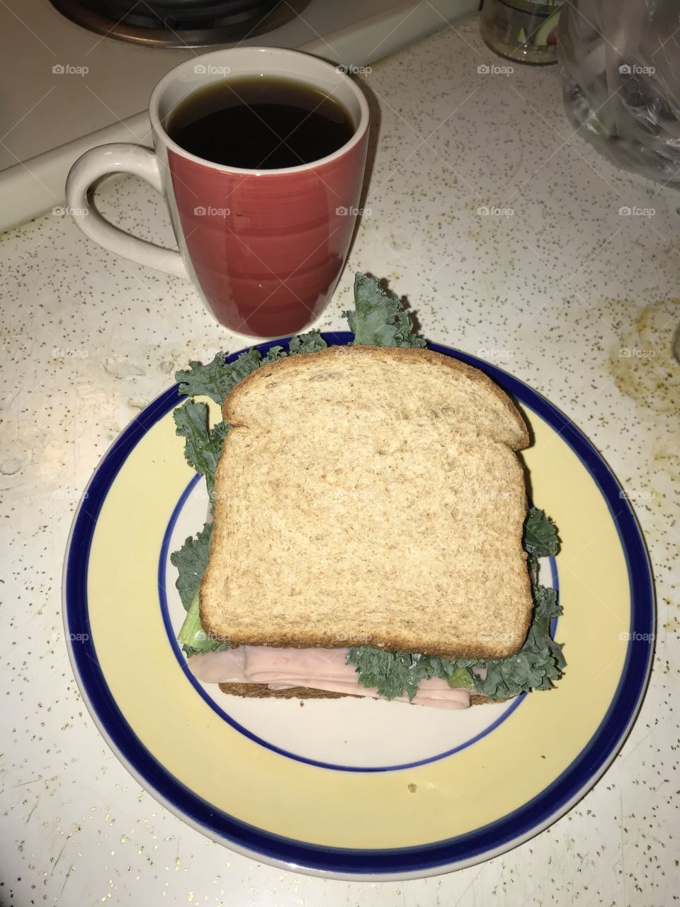 Instant black coffee with a ham sandwich for a late night dinner. The two make a simple yet enjoyable meal together.