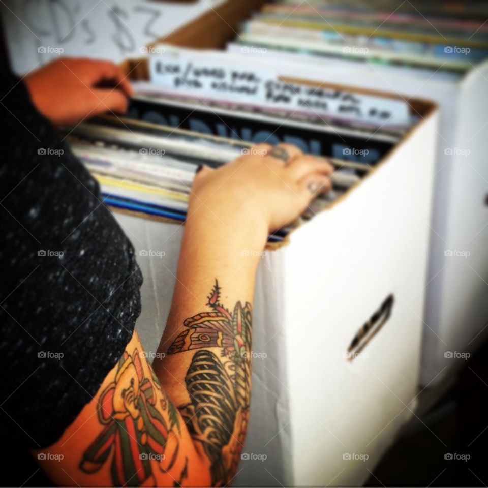 Tattooed arm browsing records