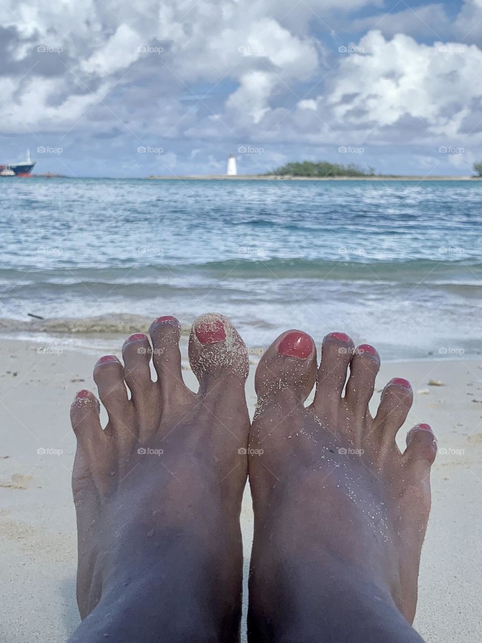 A woman’s feet in front of the beach Nassau Bahamas. 