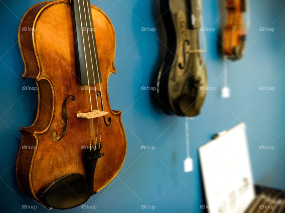 Violins hanging from wall, carbon fiber and wooden