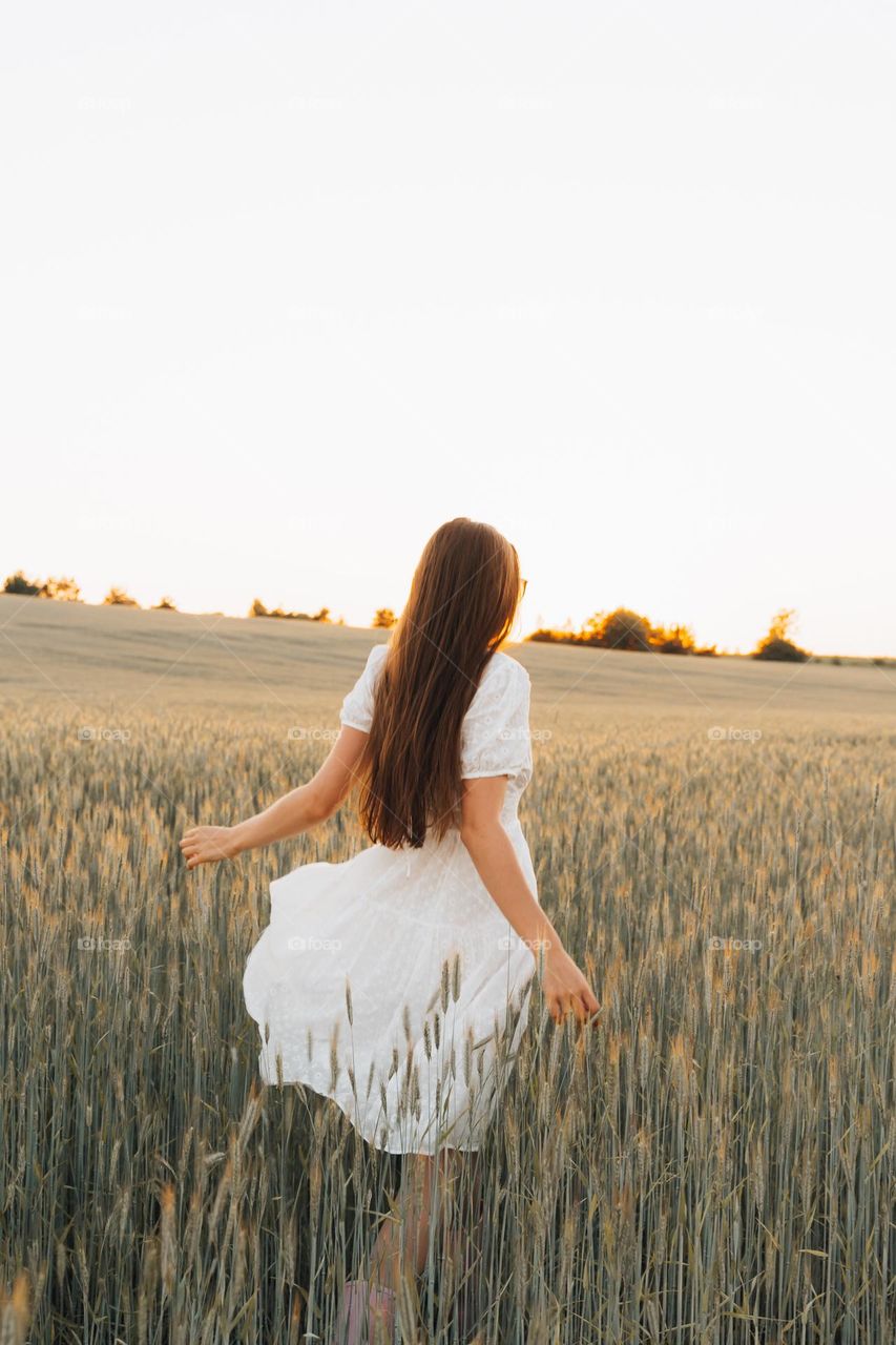 Natural Long hair brown straight hair woman in wheat field enjoying nature 