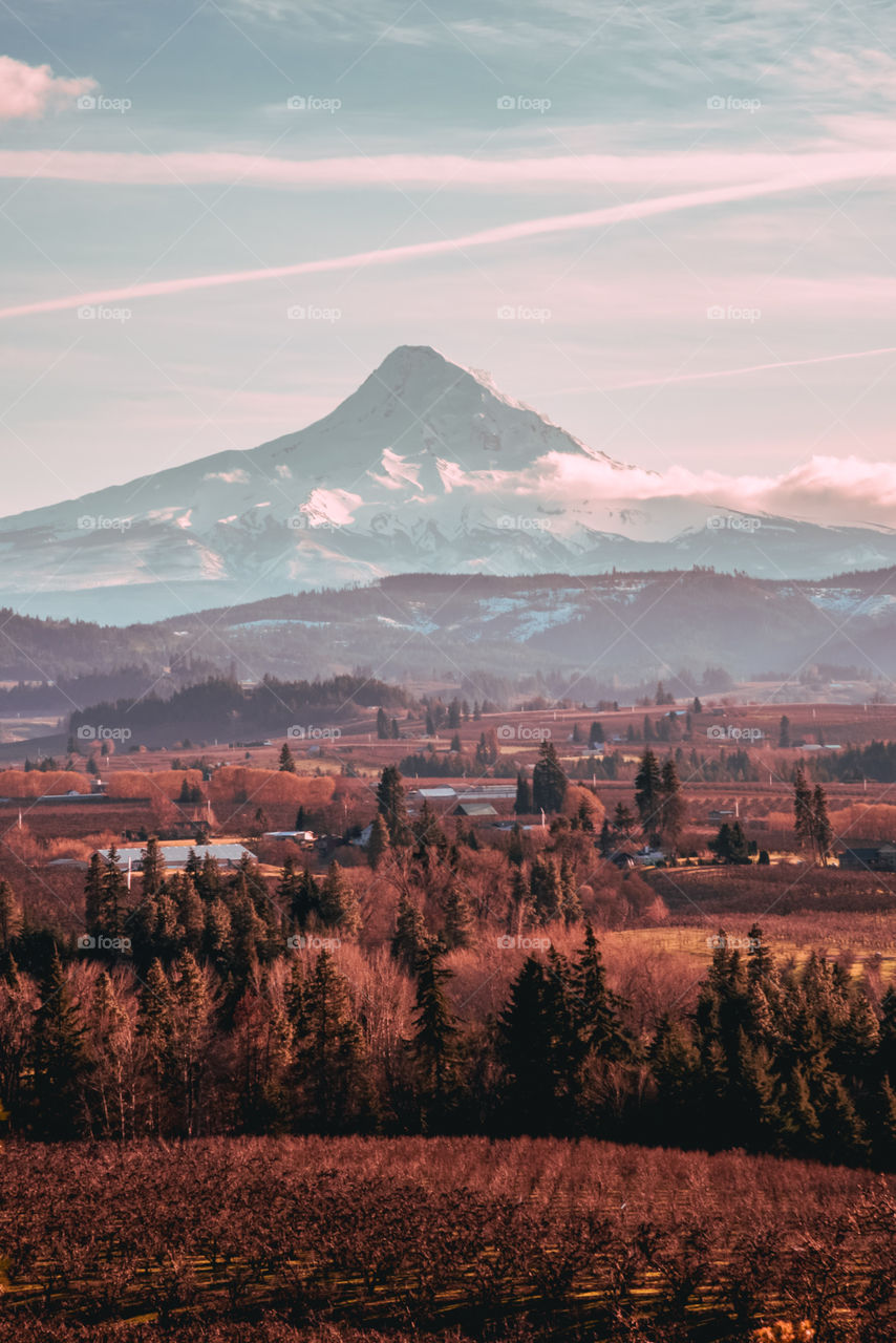 Mountain dominating over small rural town and valley hills 