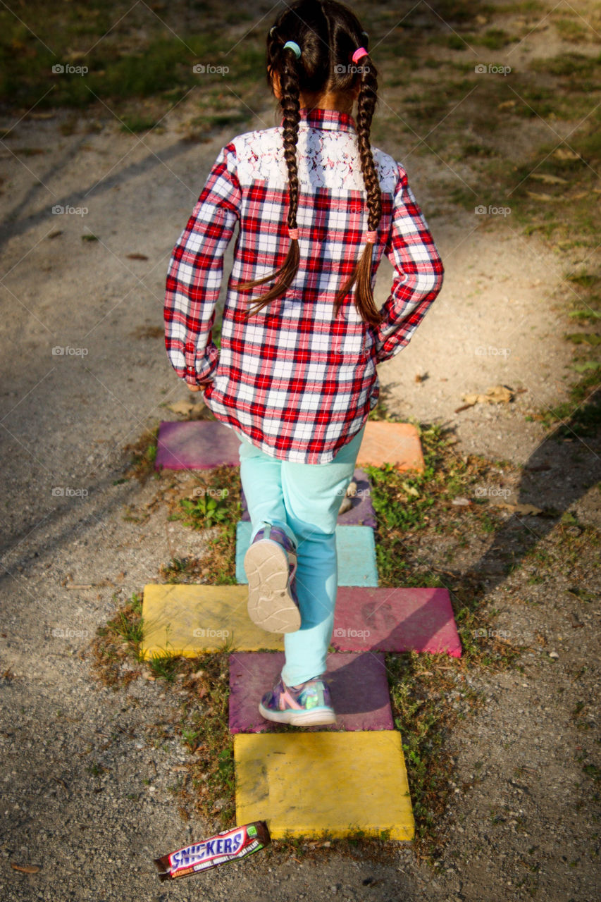 Active child outdoors playing hopscotch