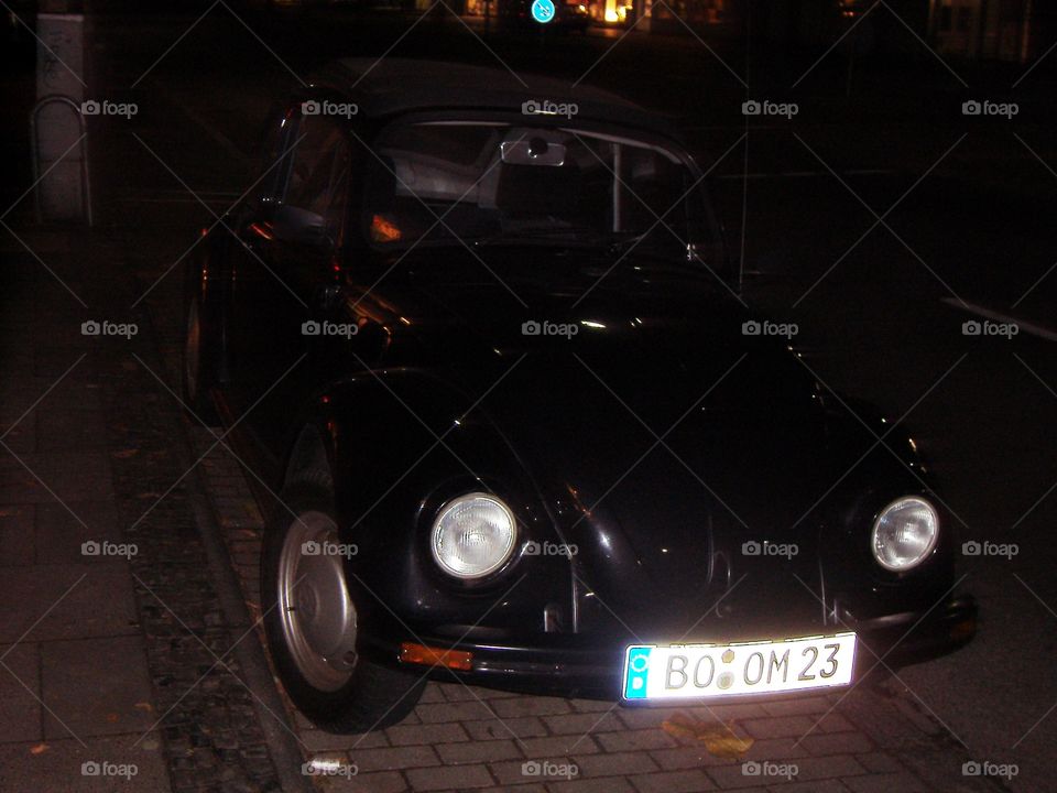 Old black Volkswagen Beetle in the night street