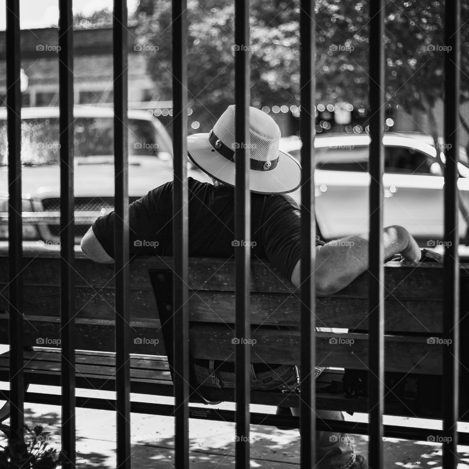 Man Sitting Behind Fence