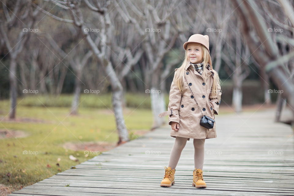 Stylish little girl standing outdoor. Autumn season 