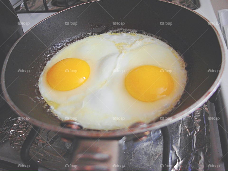 Sunny side up eggs cooking on the stove 