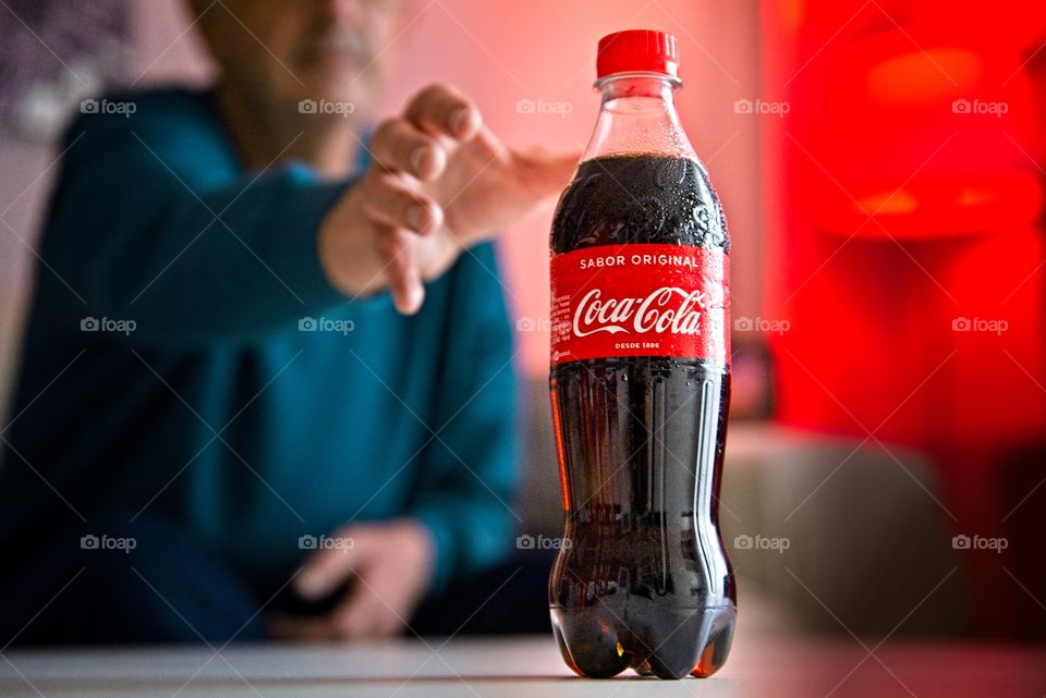 Man taking a bottle of Coca Cola in the living room