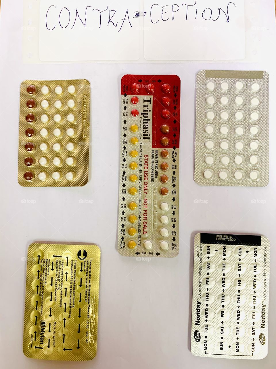 Blister strips of contraceptives pills on a white poster used for health education purposes. 