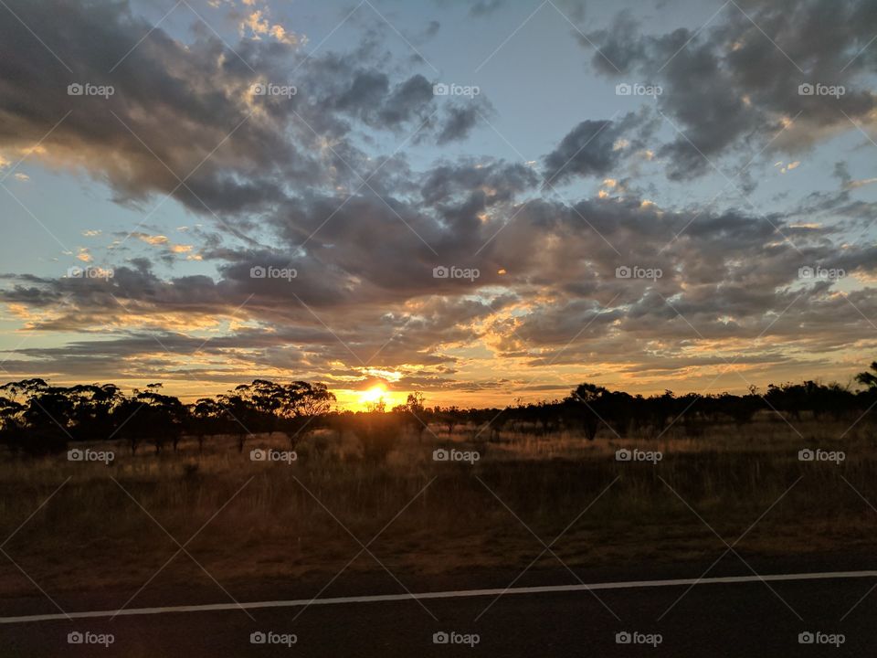 Travelling along an outback road with an awesome sunset to look at