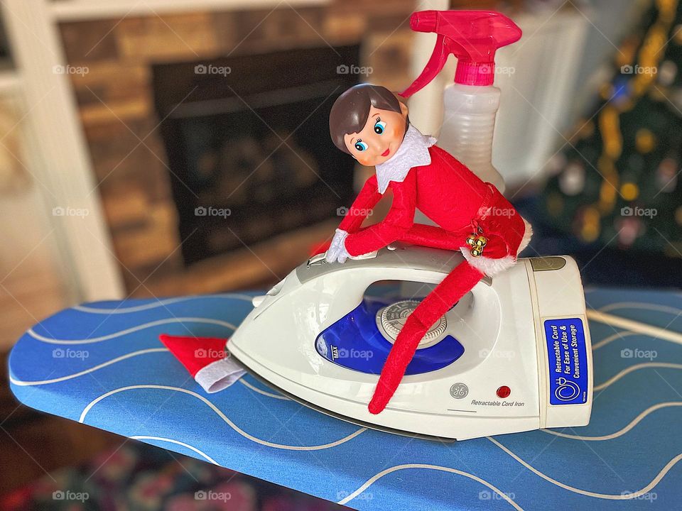 Elf on the Shelf ironing her hat, elf on the shelf antics, fun with children, spreading holiday cheer, elf on the shelf ideas, funny elf on the shelf scenes, helpful elf on the shelf, Christmas traditions