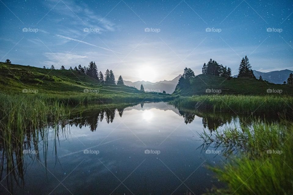 The Moon over a mountain lake in switzerland