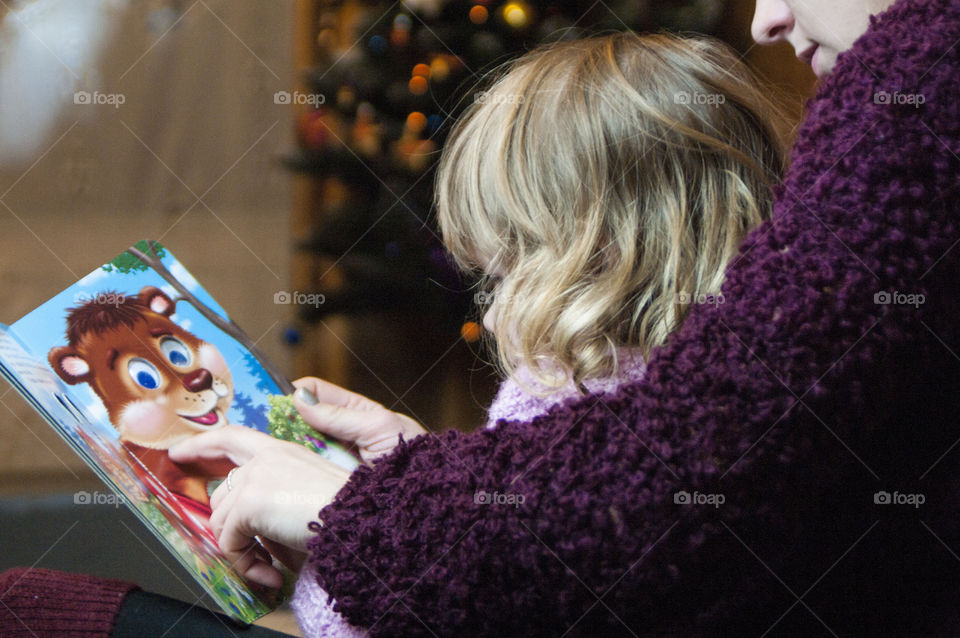 Mother little daughter reading book