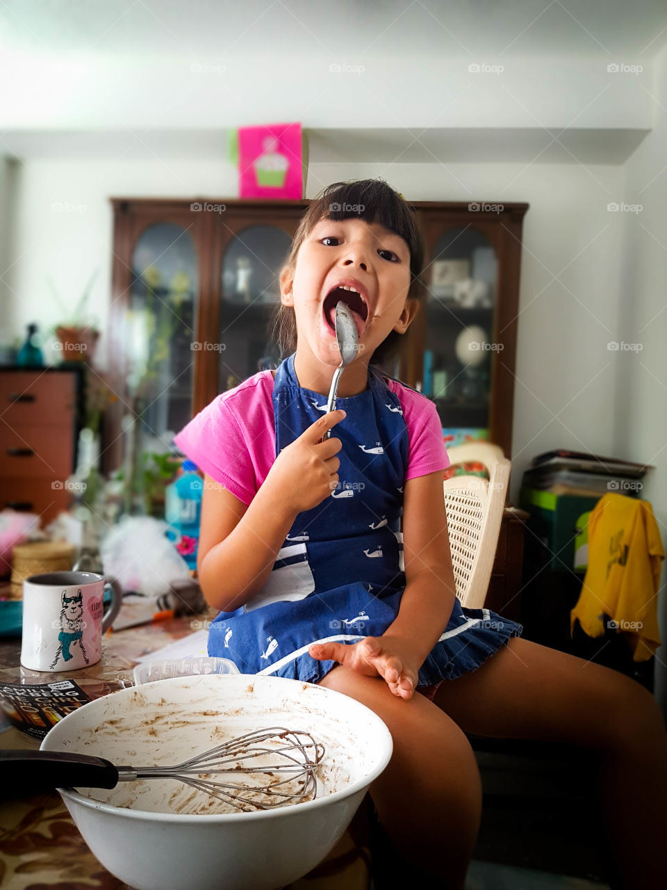 Cute little girl is helping to cook