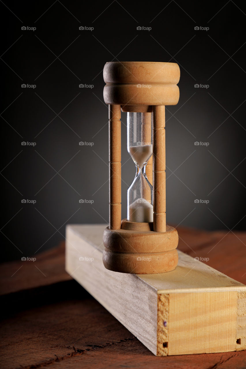 Antique wood / glass hourglass on dark background