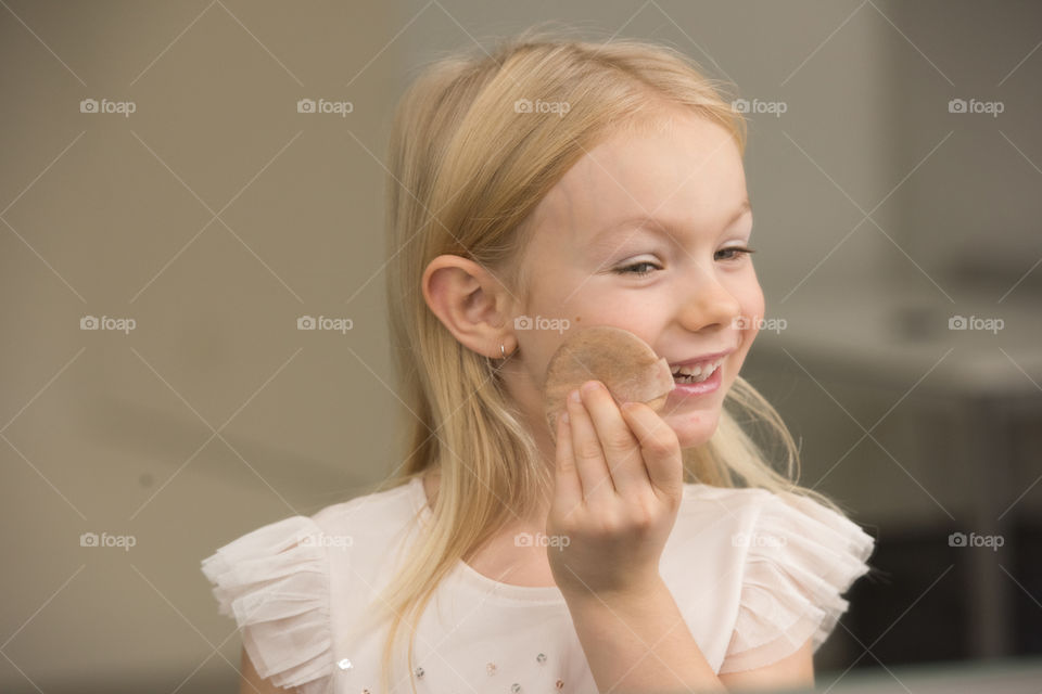 Young 6 year old Swedish girl is trying out makeup at a photostudio.