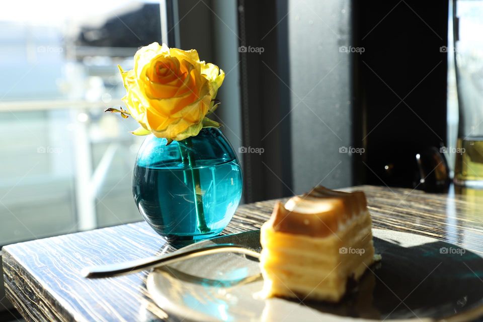 Vase with yellow rose on a tabletop 