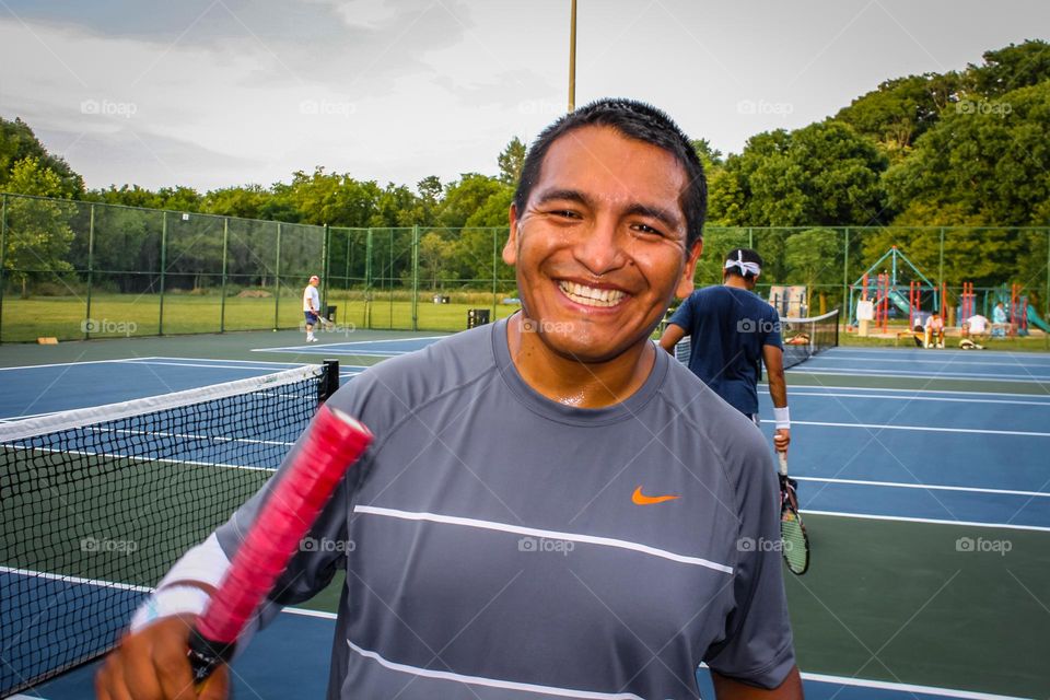 Happy fit middle-aged man on a tennis court