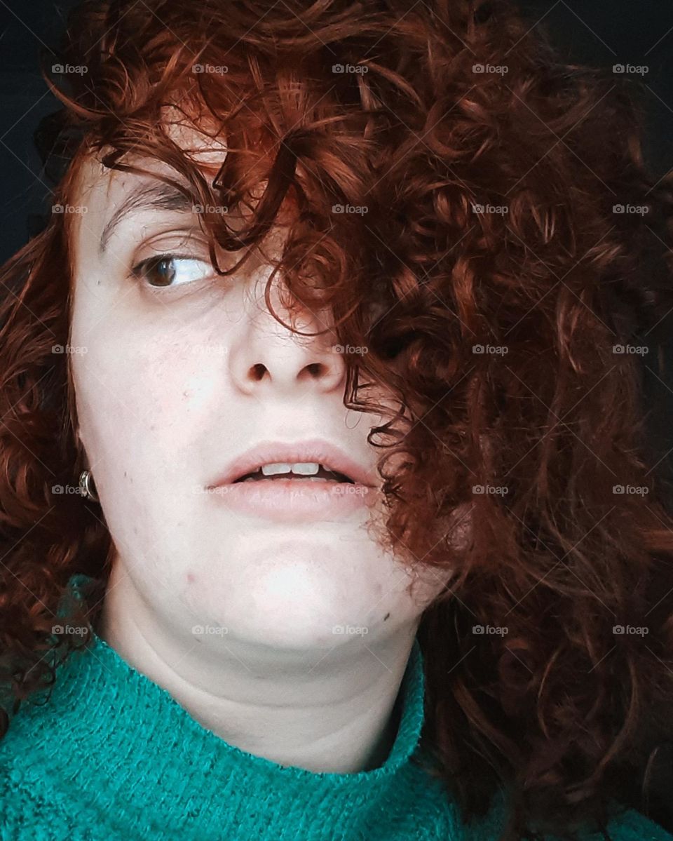 A girl with pale and white skin with red curly hair