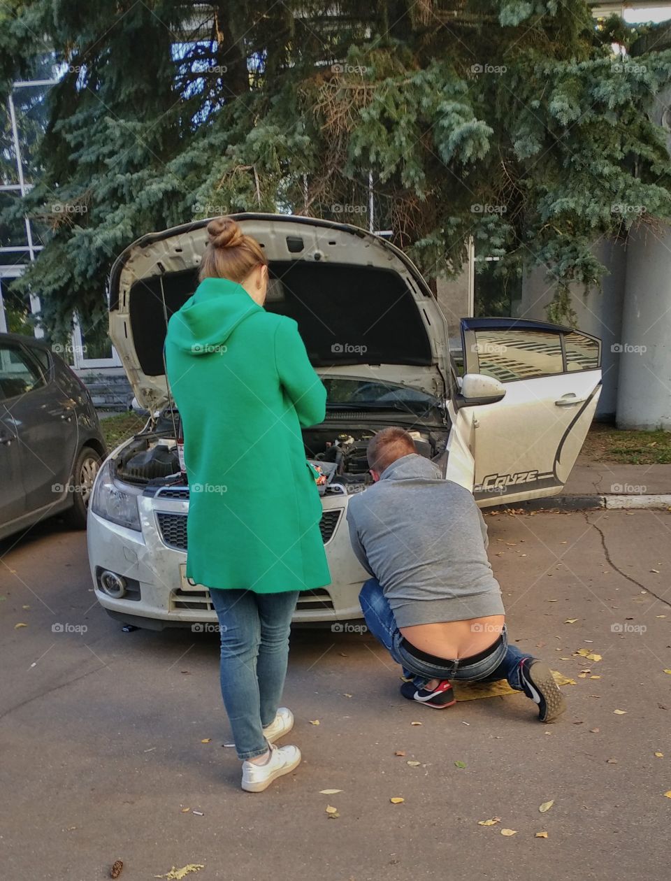 It was fun to watch this sight. I think it's pretty universal. Man is trying to fix a car while woman is watching. 