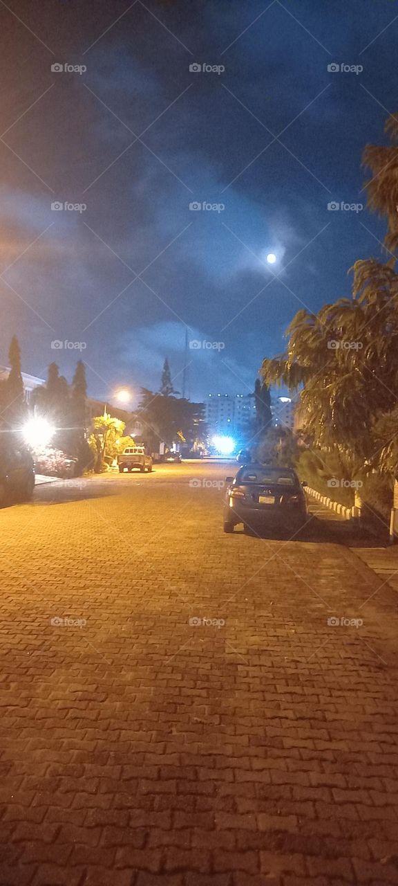 Full moon, illusion of many moons made by street lights. Beautiful blue moon on ground