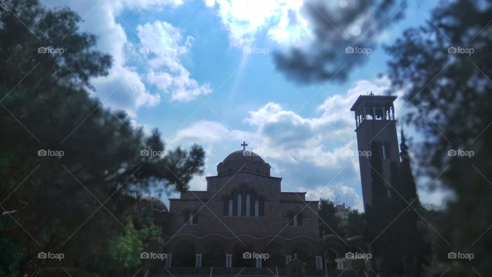 The sun shines above a church in Athens
