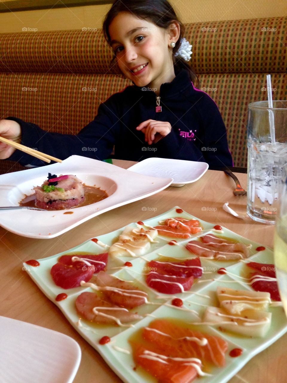 Girl eating food with chopsticks in restaurant