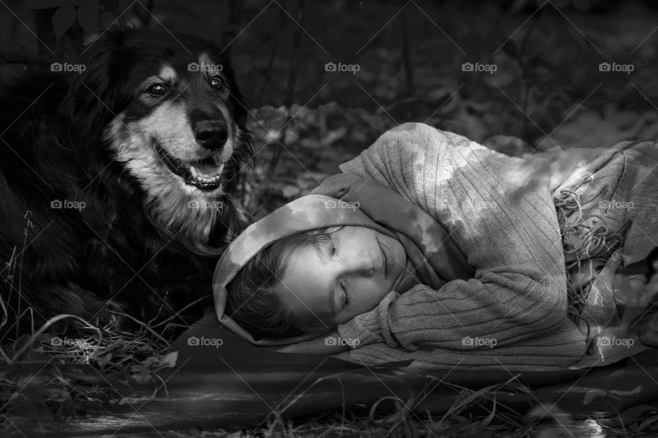 A girl with a dog sleeps in the woods at. night