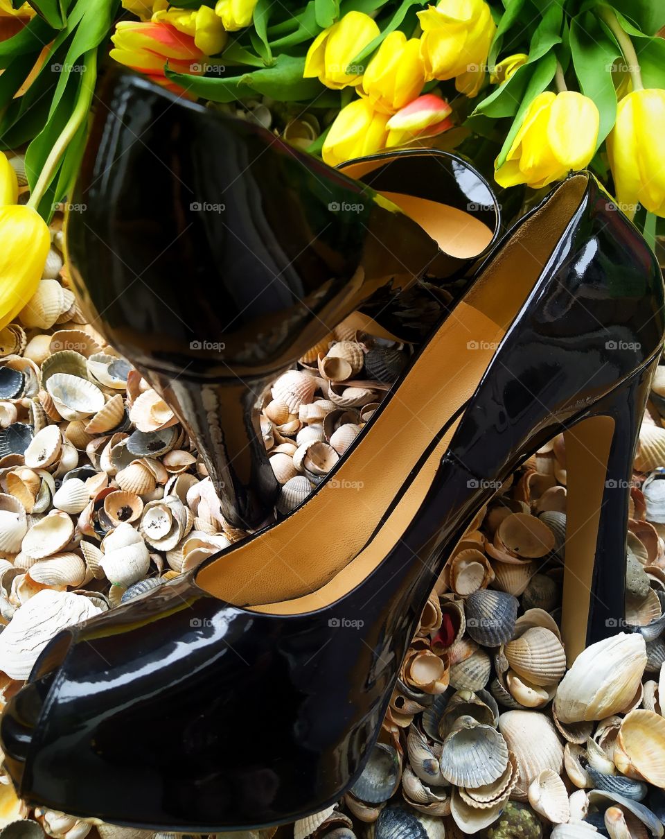 Spring.  Seashells.  High-heeled shoes and spring flowers yellow tulips