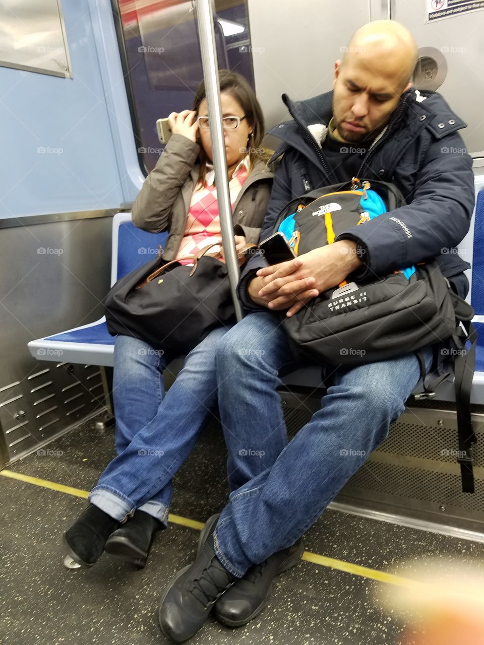 man and woman on train talking - but not to each other! phone sideways
