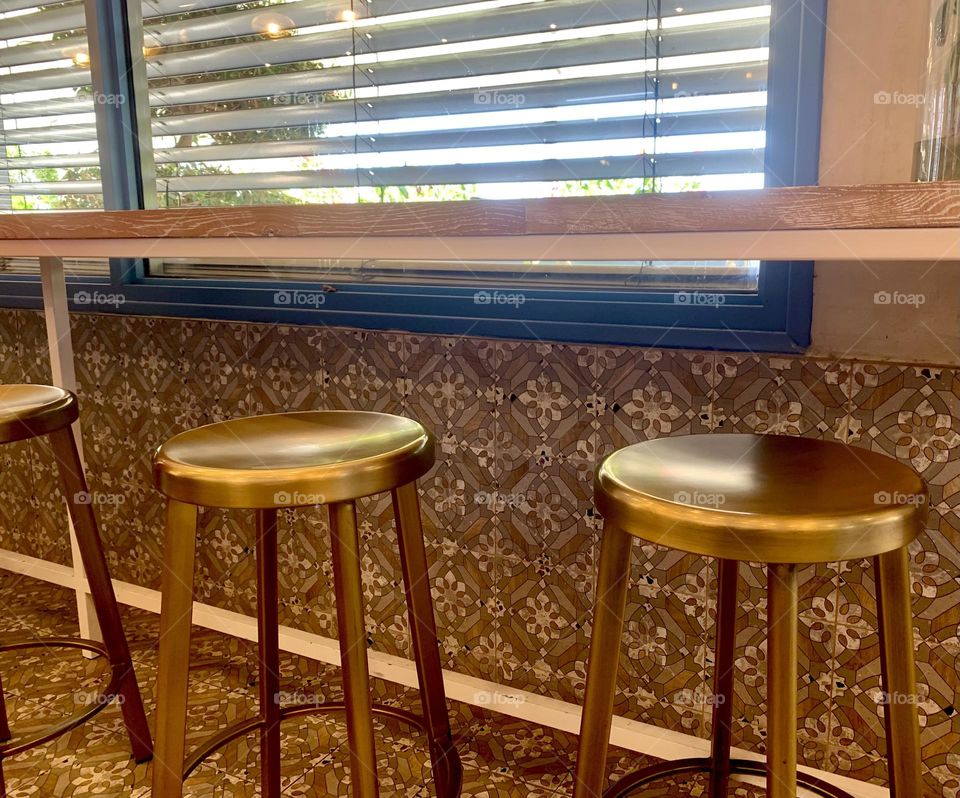 Golden bar chairs inside the coffee shop