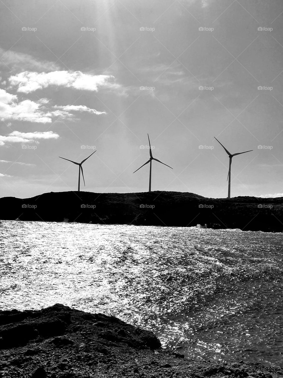 three wind turbines alone on the coast- Black and white