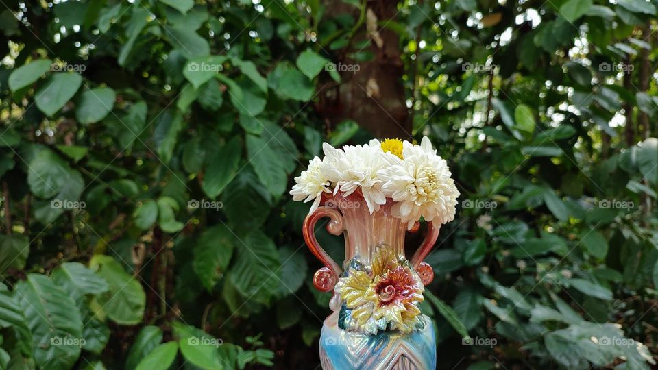 Beautiful white flowers in a colourful flowerpot with a flower sculpture, Flowers in a vase, colourful vase, white flowers in a vase