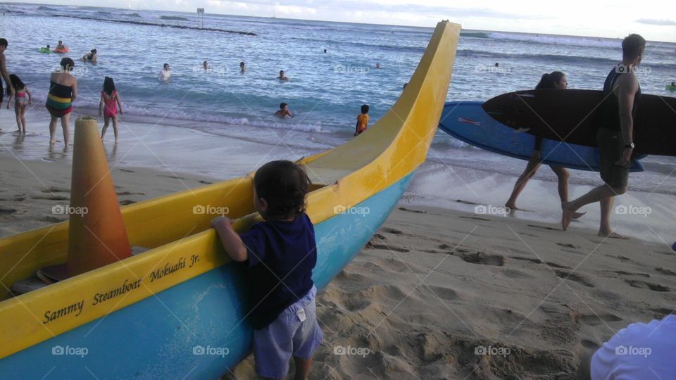 toddler looking at outrigger canoe on waikiki beach