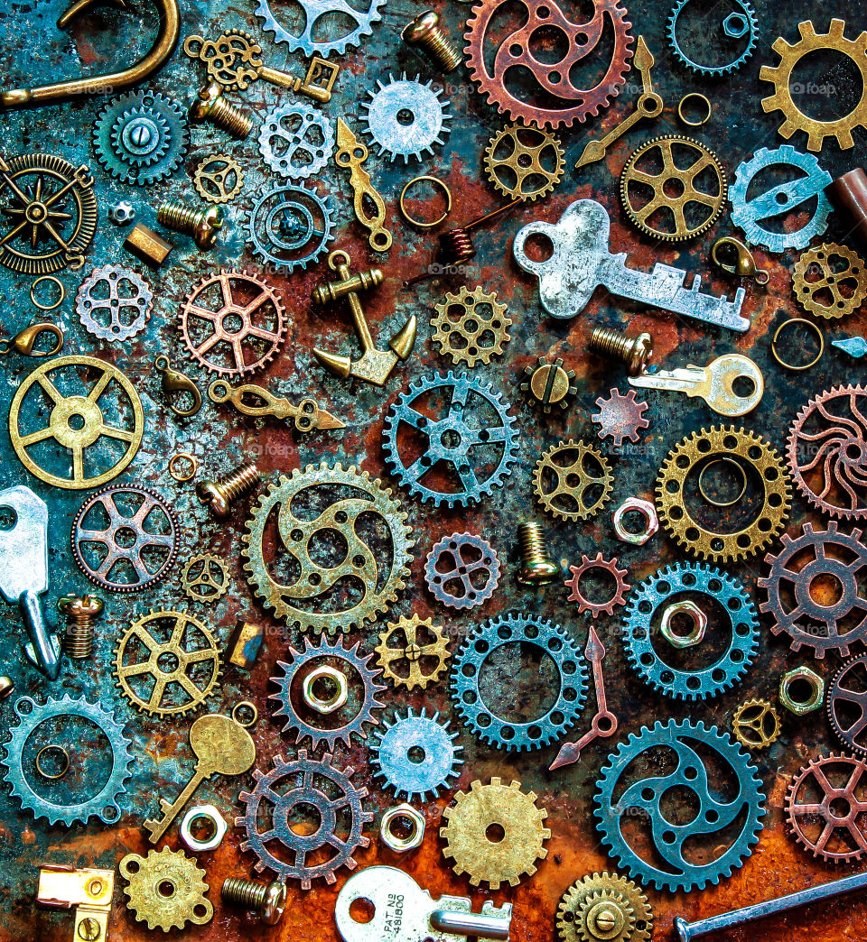 Metallic themed flat lay, featuring cogs, keys, nuts, bolts, clock hands